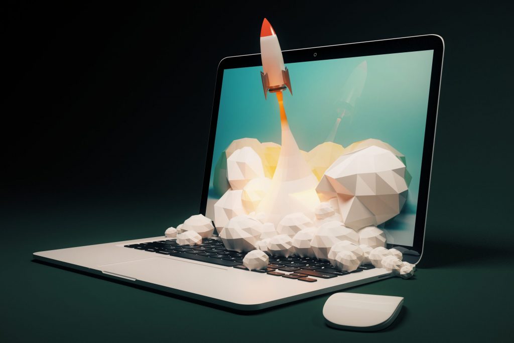Startup concept with rocket flying from laptop screen on black background.